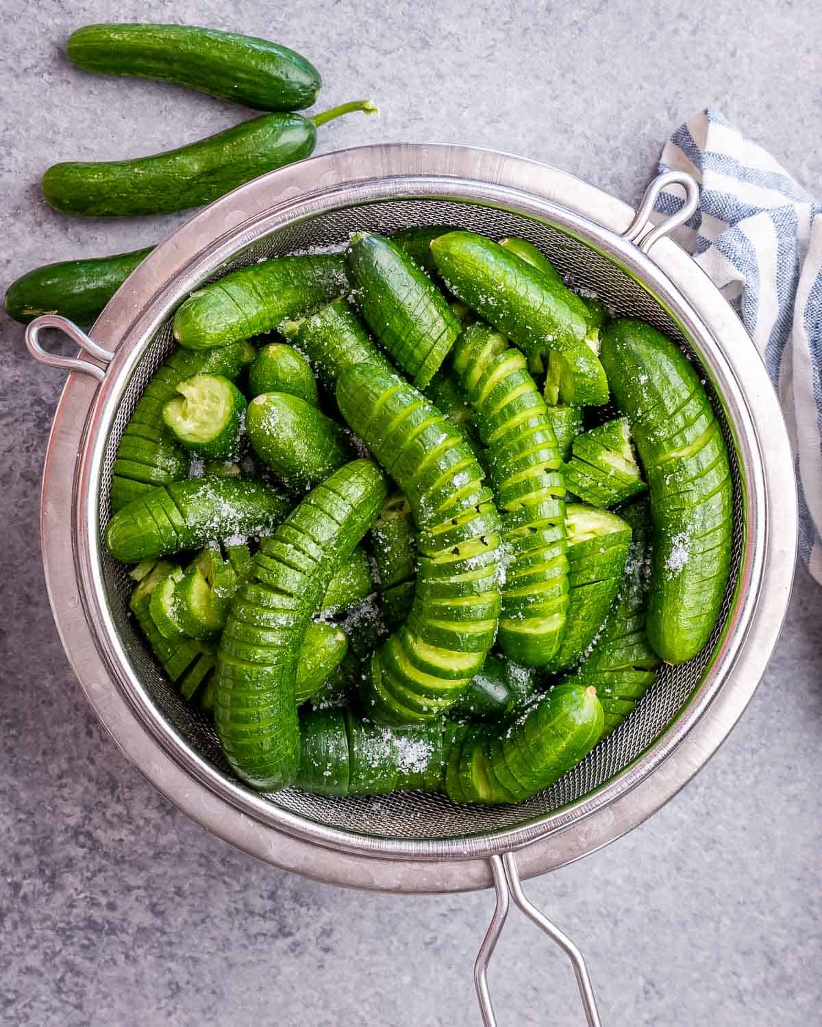 Salted cucumbers in a colander.