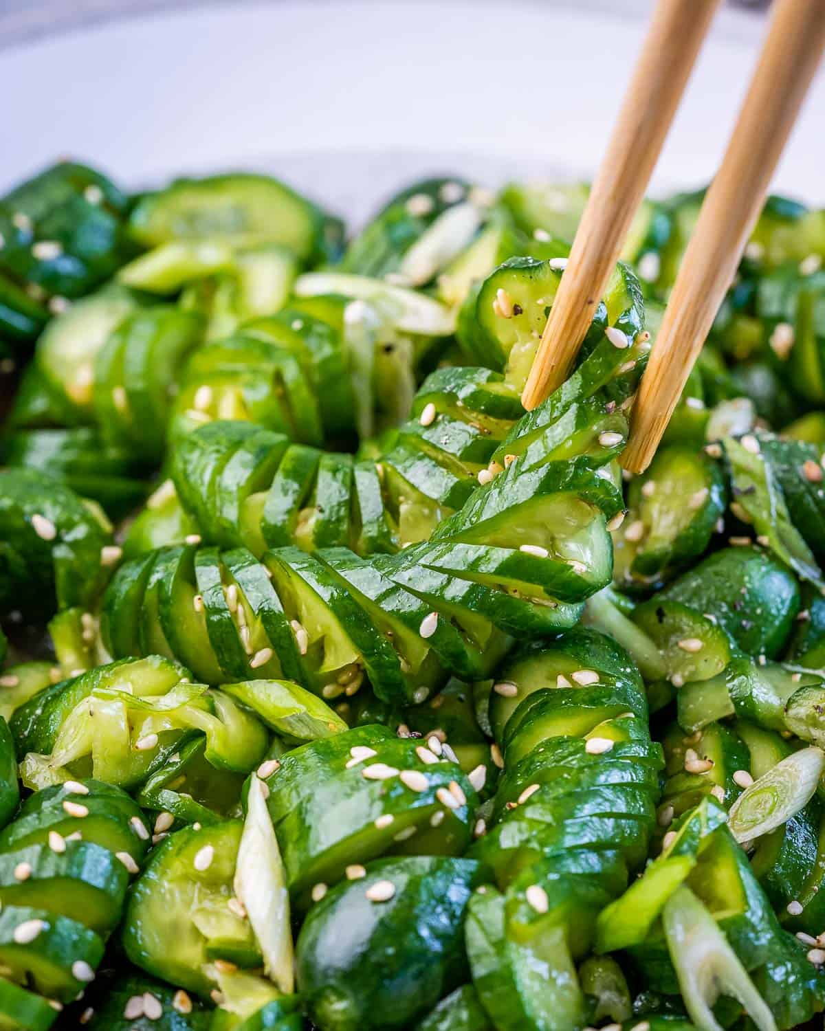 Using chopsticks to pick up cucumber in a cucumber salad.