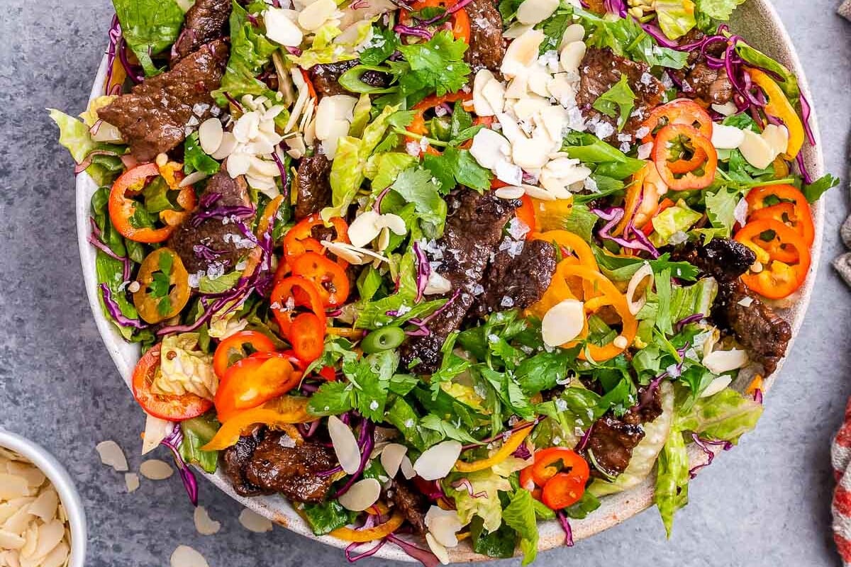 thai beef salad in a round white bowl.