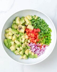 all avocado salsa ingredients added to a bowl.