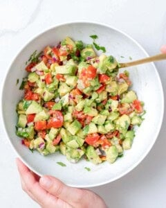 spoon mixing salsa in a bowl.