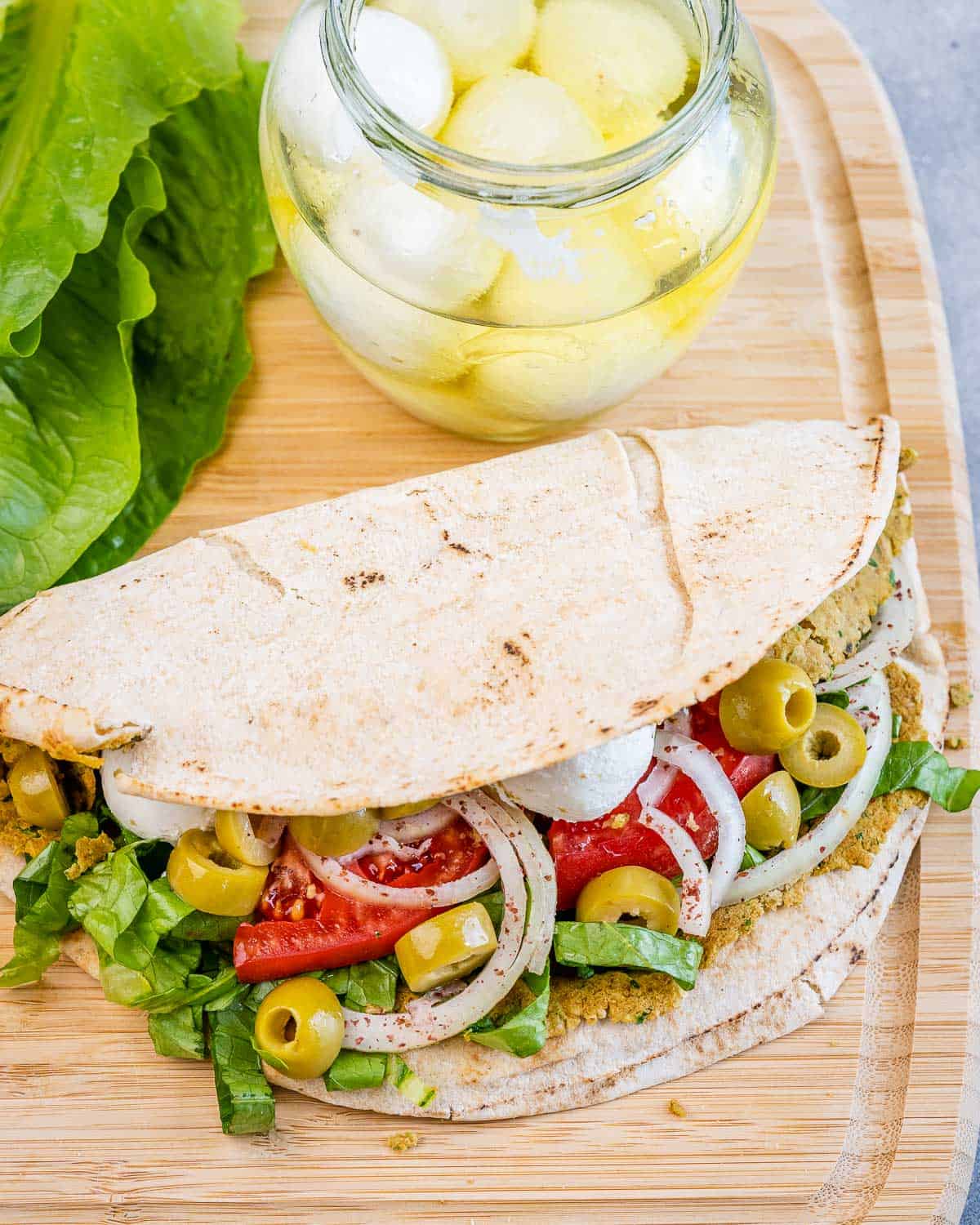 folded smash falafel pita on a cutting board.