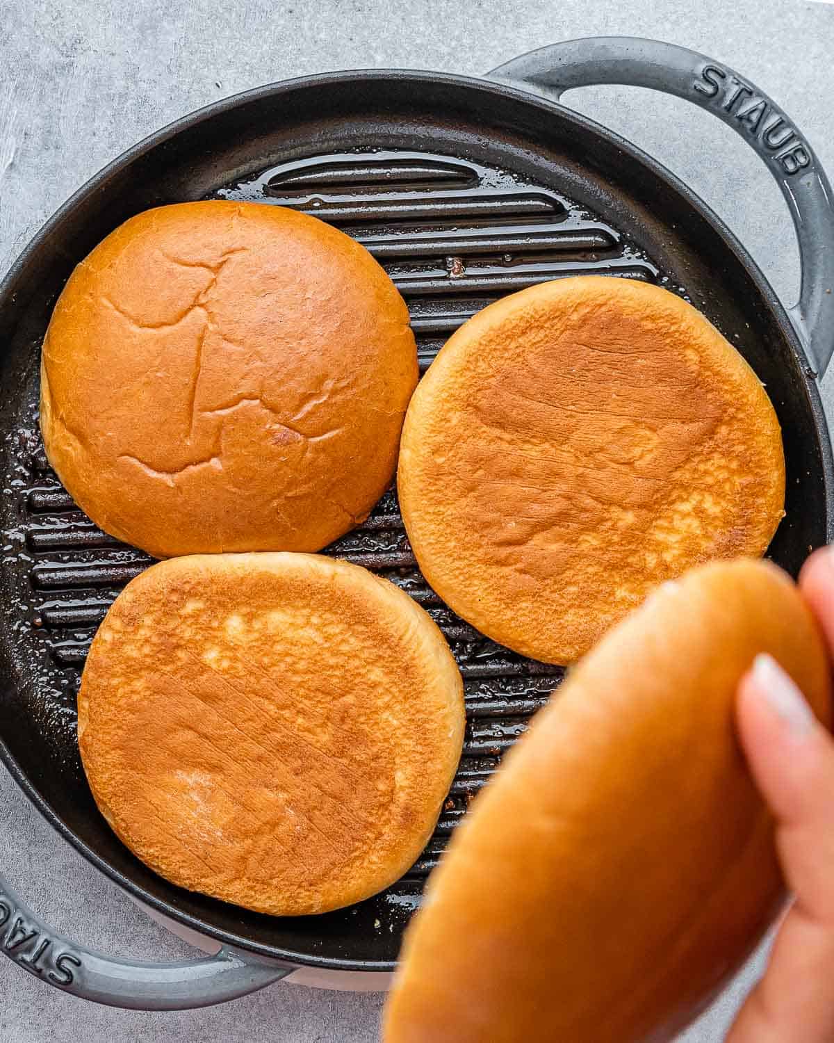 Toasting hamburger buns on a grill pan.