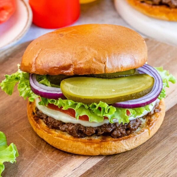 A hamburger on a wooden board.