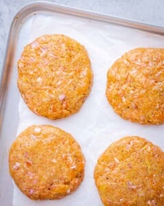 Salmon patties on parchment paper.