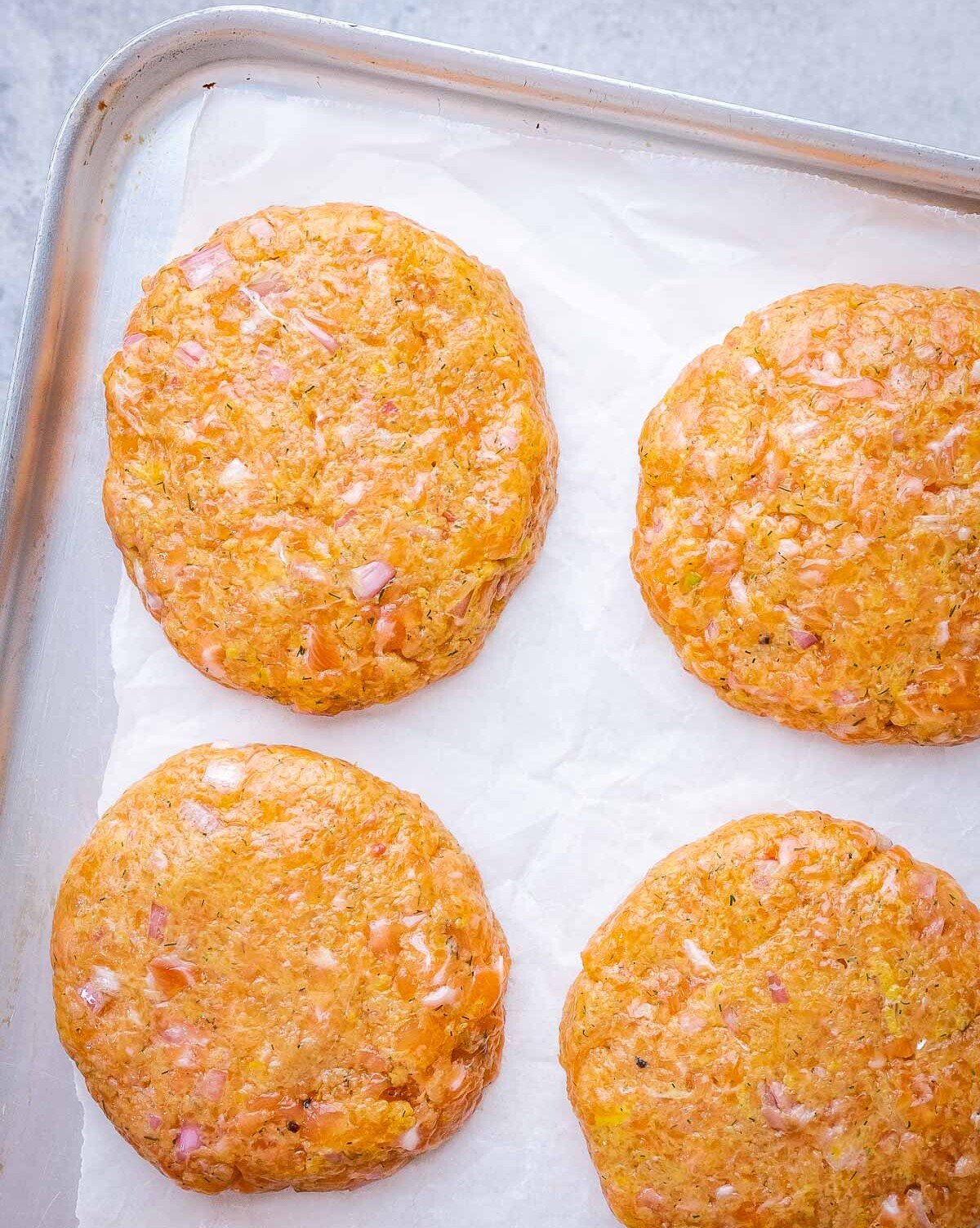 Salmon patties on parchment paper.