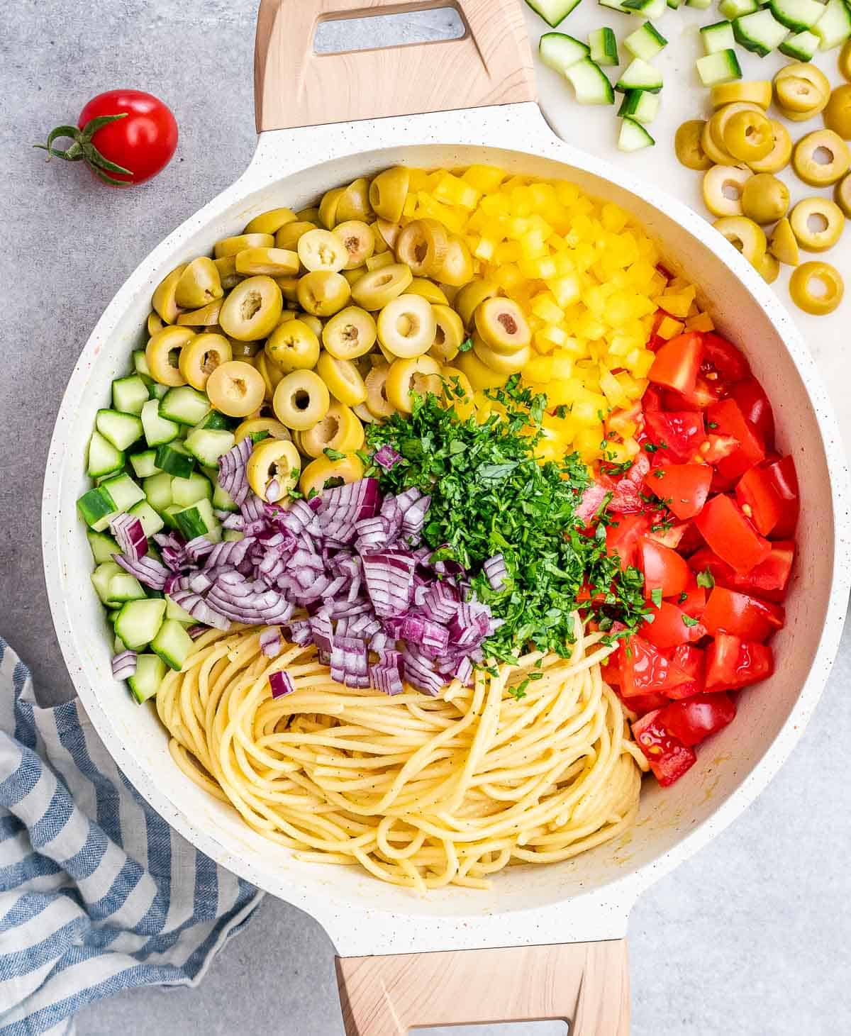 chopped veggies added over spaghetti in a sound bowl.