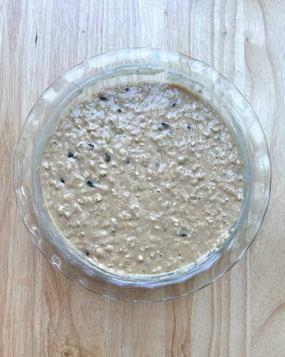 batter for banana oat muffins mixed in with chocolate chips in a bowl.