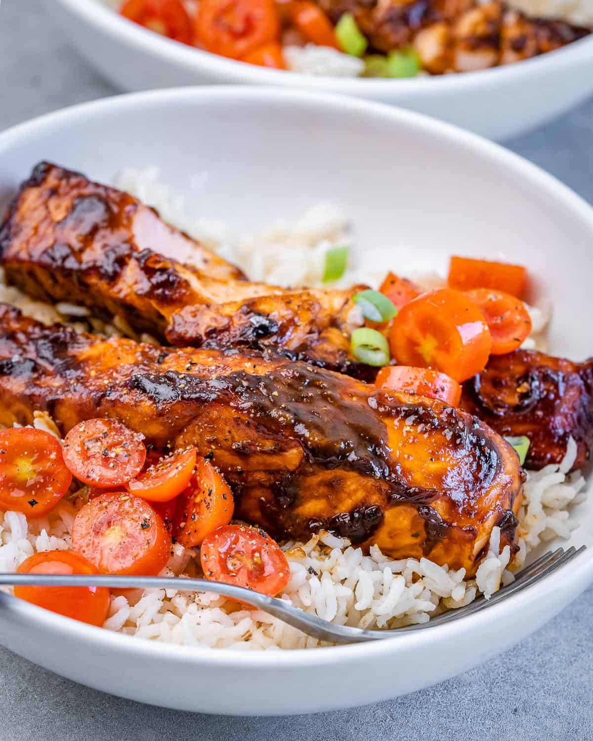 Balsamic glazed salmon served over rice with tomatoes.