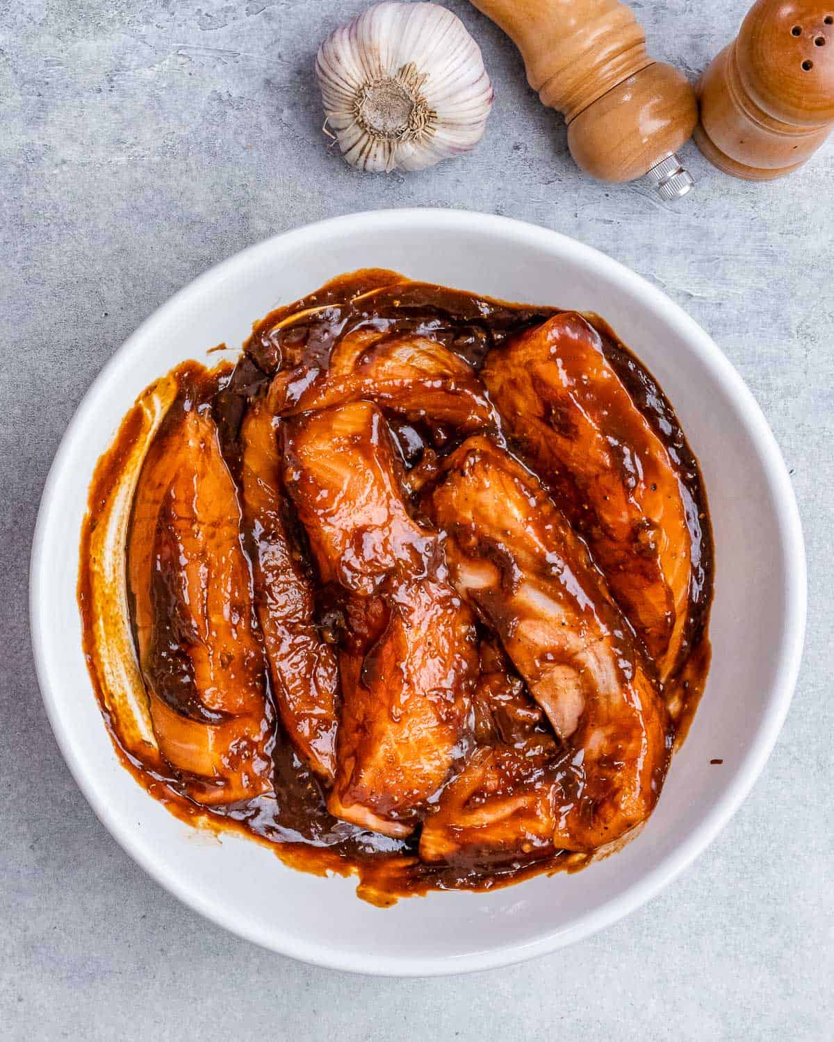 Marinating salmon filets in a white bowl.