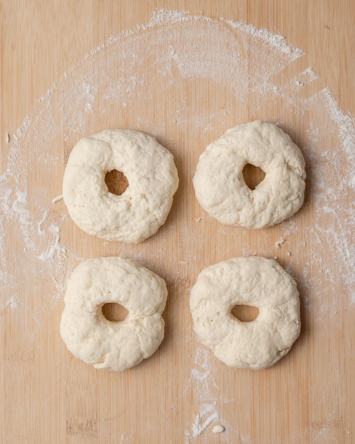 4 bagel-like dough formed with a hole in the middle of them.