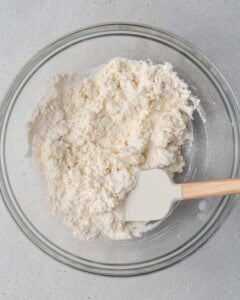 cottage cheese is mixed with flour in a round bowl.