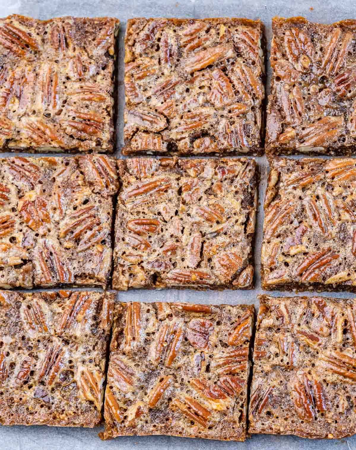 Healthy pecan pie bars on parchment paper.