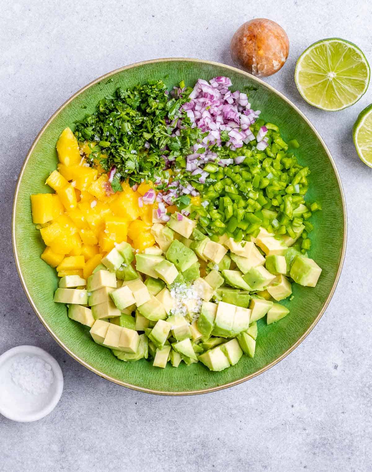  Chopped mango and veggies in a bowl to make salsa.