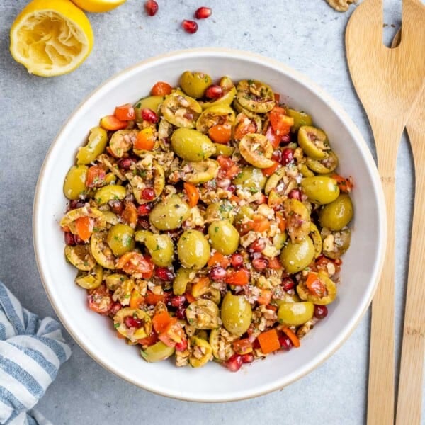 Olive salad fully mixed and ready to serve, with a lemon wedge on the side.