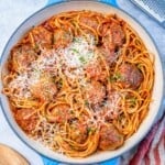 Large pan filled with cooked spaghetti and meatballs, ready to be served.