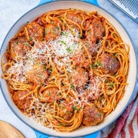Large pan filled with cooked spaghetti and meatballs, ready to be served.