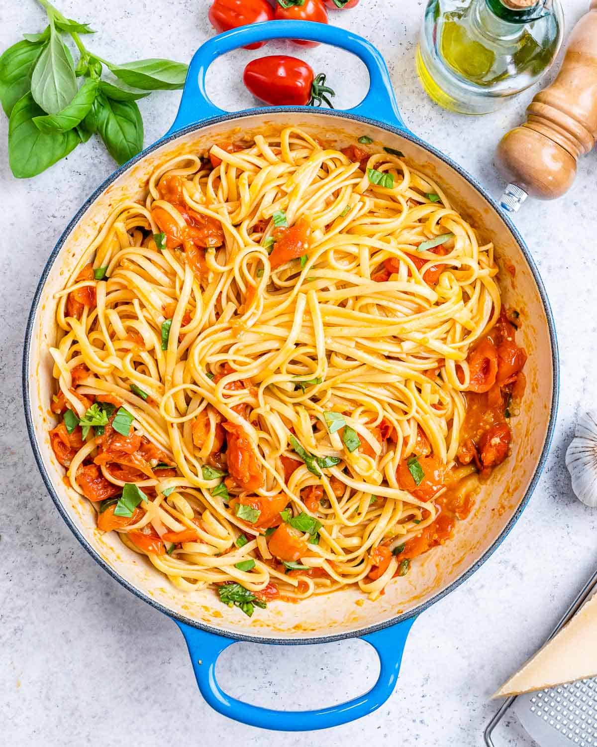 Cooked spaghetti in a strainer just after boiling, being lifted with tongs.