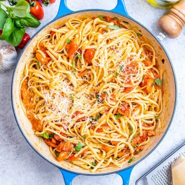 Cooked spaghetti fully coated in tomato basil sauce, ready to serve from a round deep skillet.