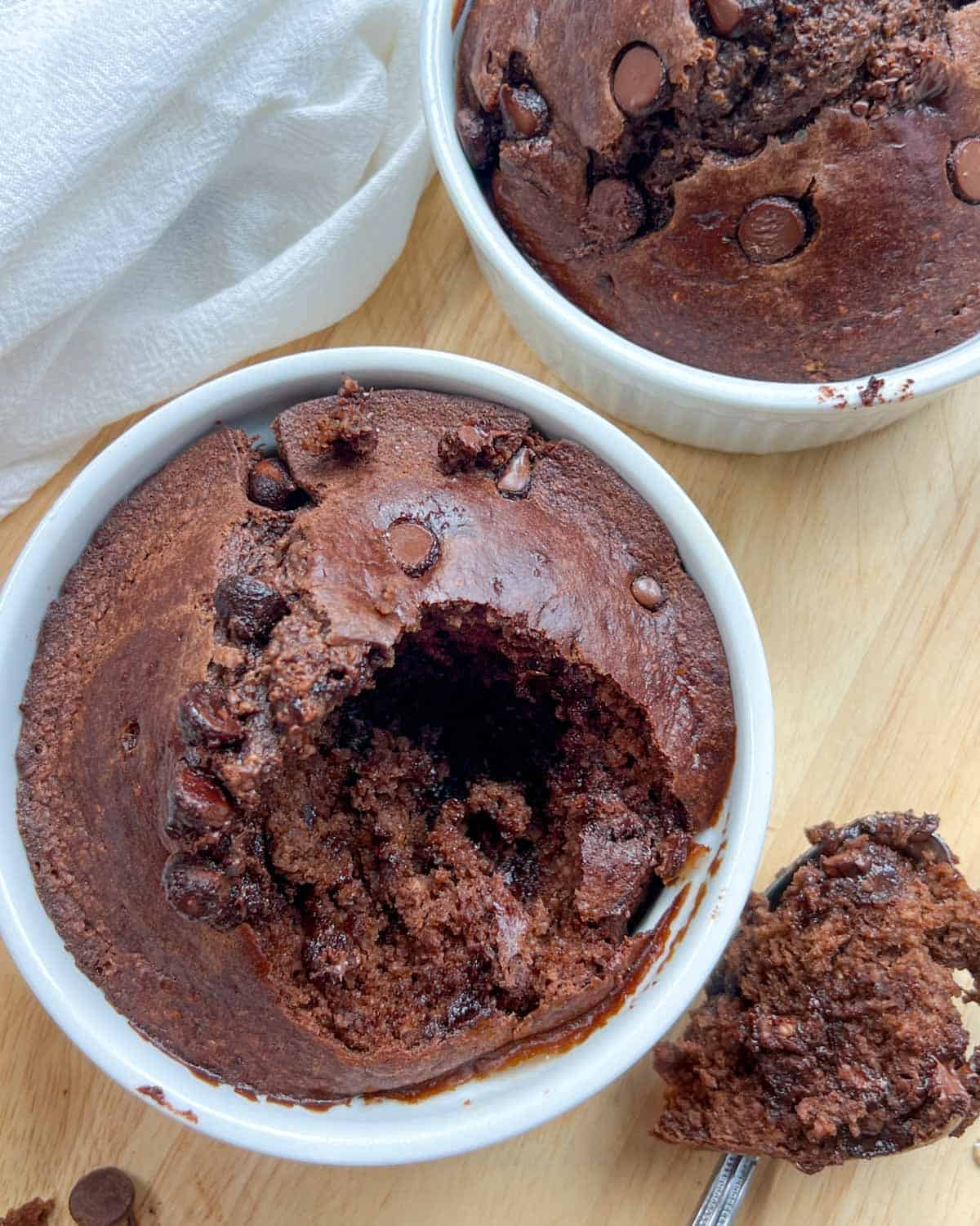 a spoonful of chocolate cake taken out of the baked oats bowl and placed on the flat surface on the right of the bowl.