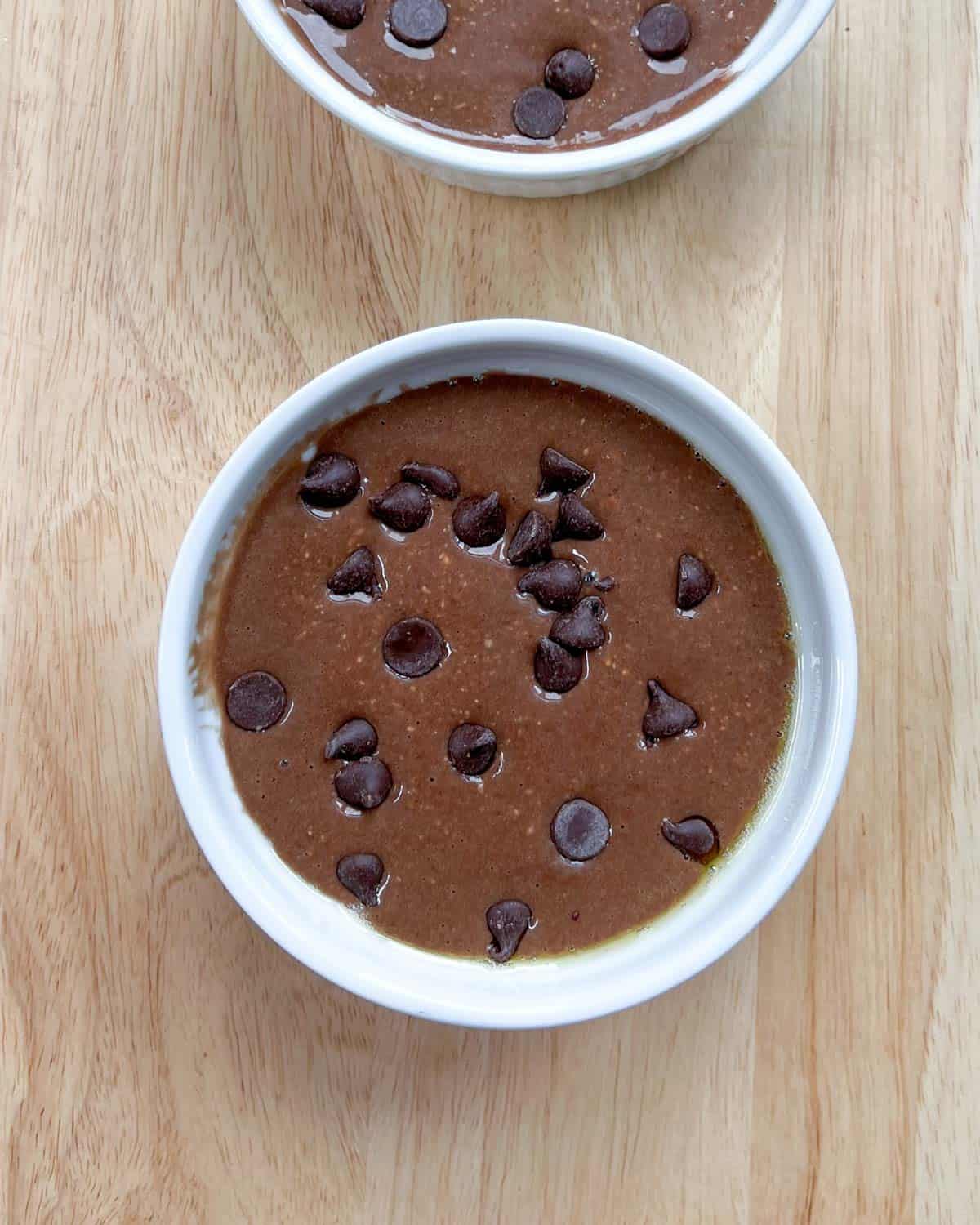 batter in ramekin topped with more chocolate chips.