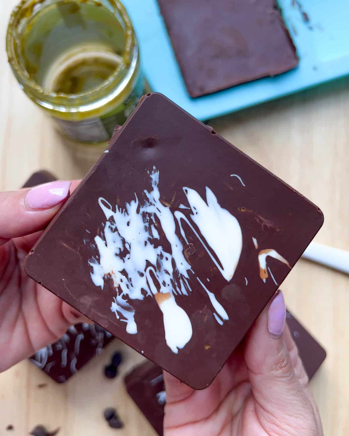 hand holding a square chocolate bar.