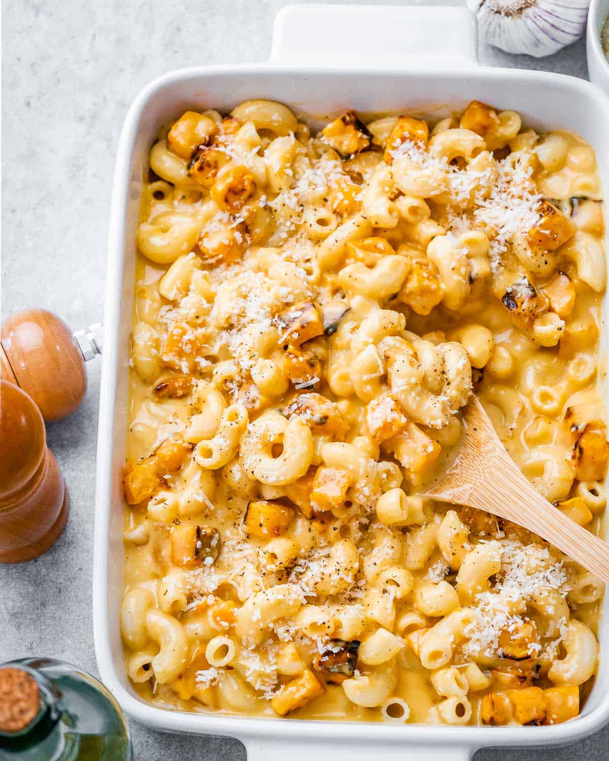 A white dish with mac and cheese made with added roasted butternut squash.