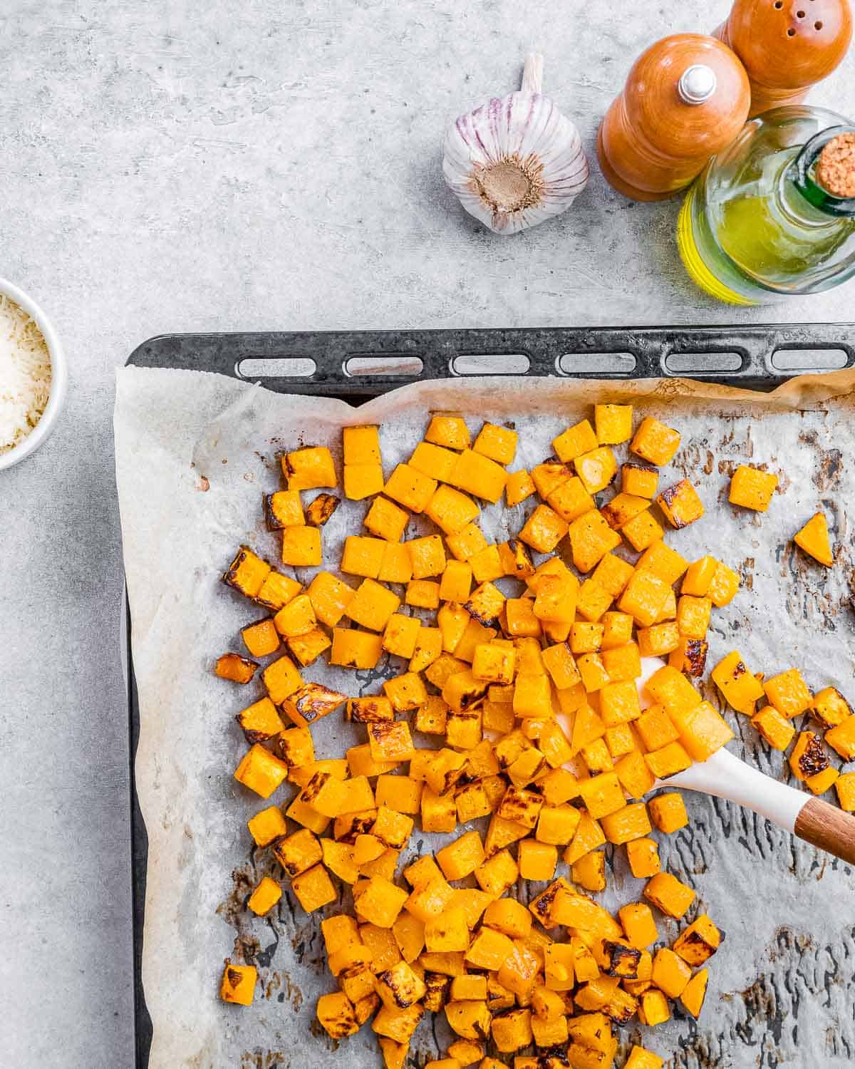 Roasted cubed butternut squash on a sheet pan.