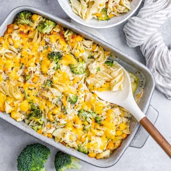a dish with chicken noodles and broccoli that's baked with cheese on top.