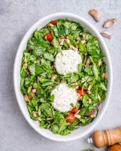 two Boursin cheese added in with veggies in a baking dish.