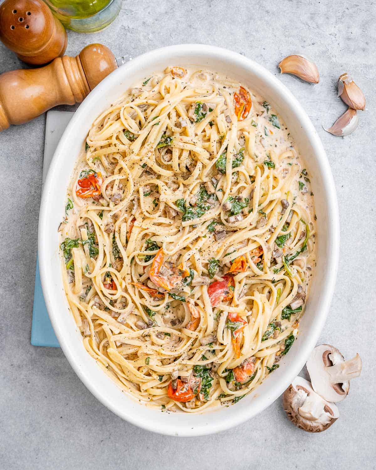 tomato and creamy pasta in a white oval dish.