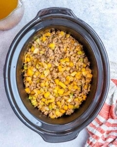 Sauteed browned meat and veggies are added to the crockpot.