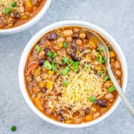 Chili with beans in a round bowl with a spoon in it.