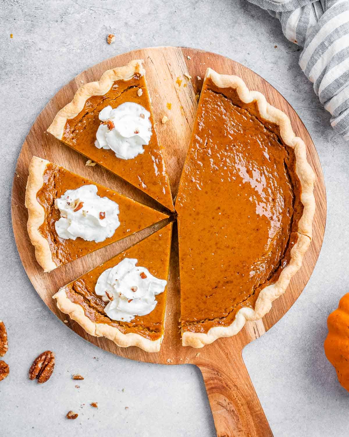 Sliced healthy pumpkin pie topped with dollops of whipped cream.