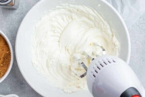 Using a mixer to combine cream cheese with
