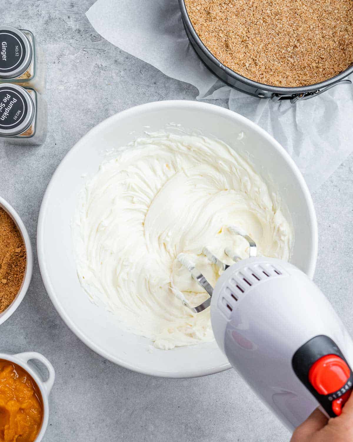 Using a mixer to whip cream cheese. 