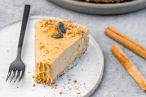 No bake pumpkin cheesecake garnished with cookie crumbs and pumpkin seeds.