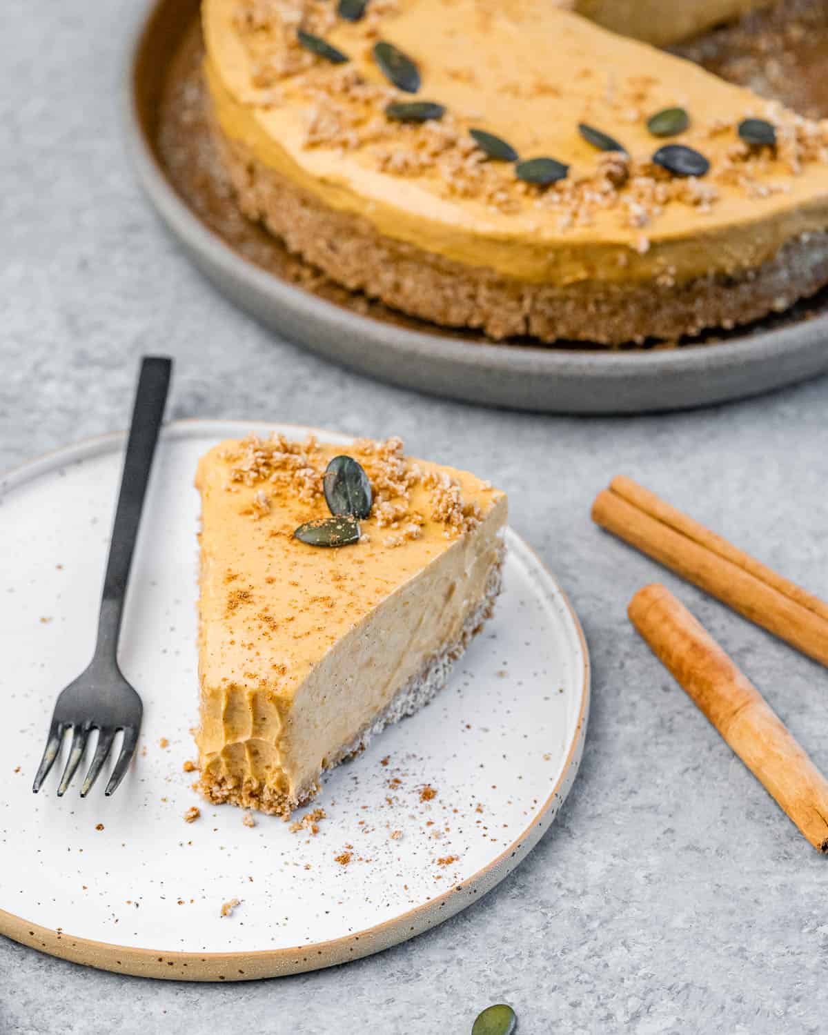 No bake pumpkin cheesecake garnished with cookie crumbs and pumpkin seeds.