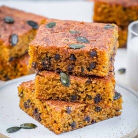 3 stacks of pumpkin cake squares over each other on a plate.