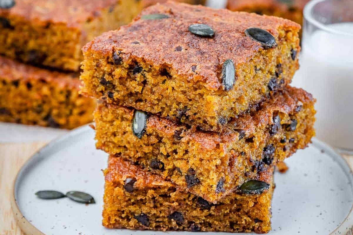 3 stacks of pumpkin cake squares over each other on a plate.