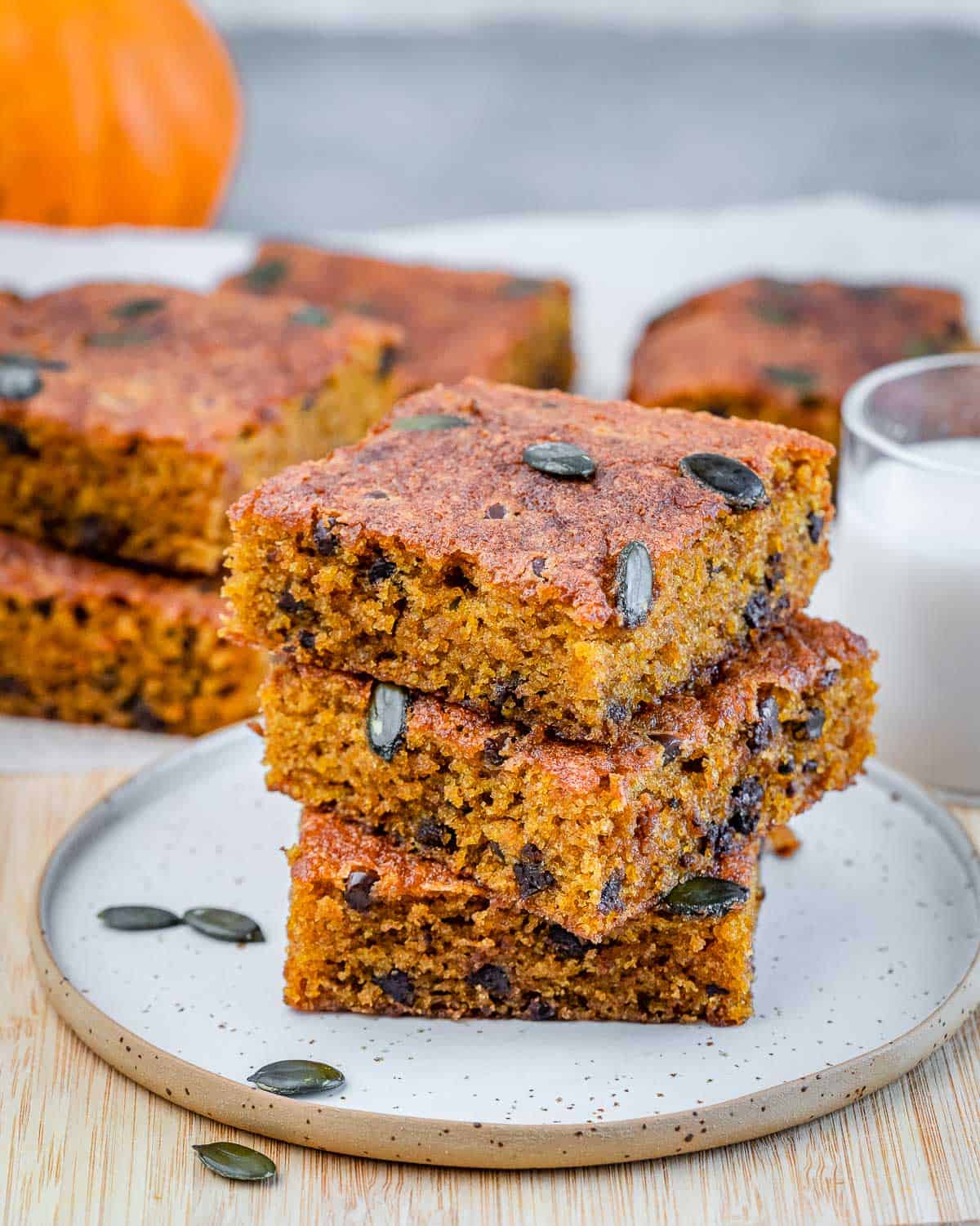 3 stacks of pumpkin cake squares over each other on a plate.