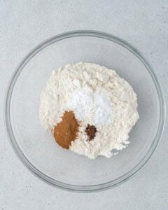 flour and spices are added to a bowl.