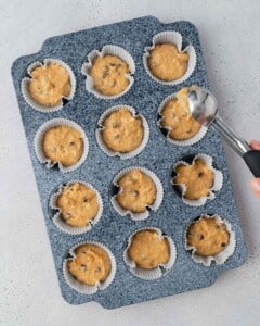 sweet potato muffin batter is added to a muffin pan.