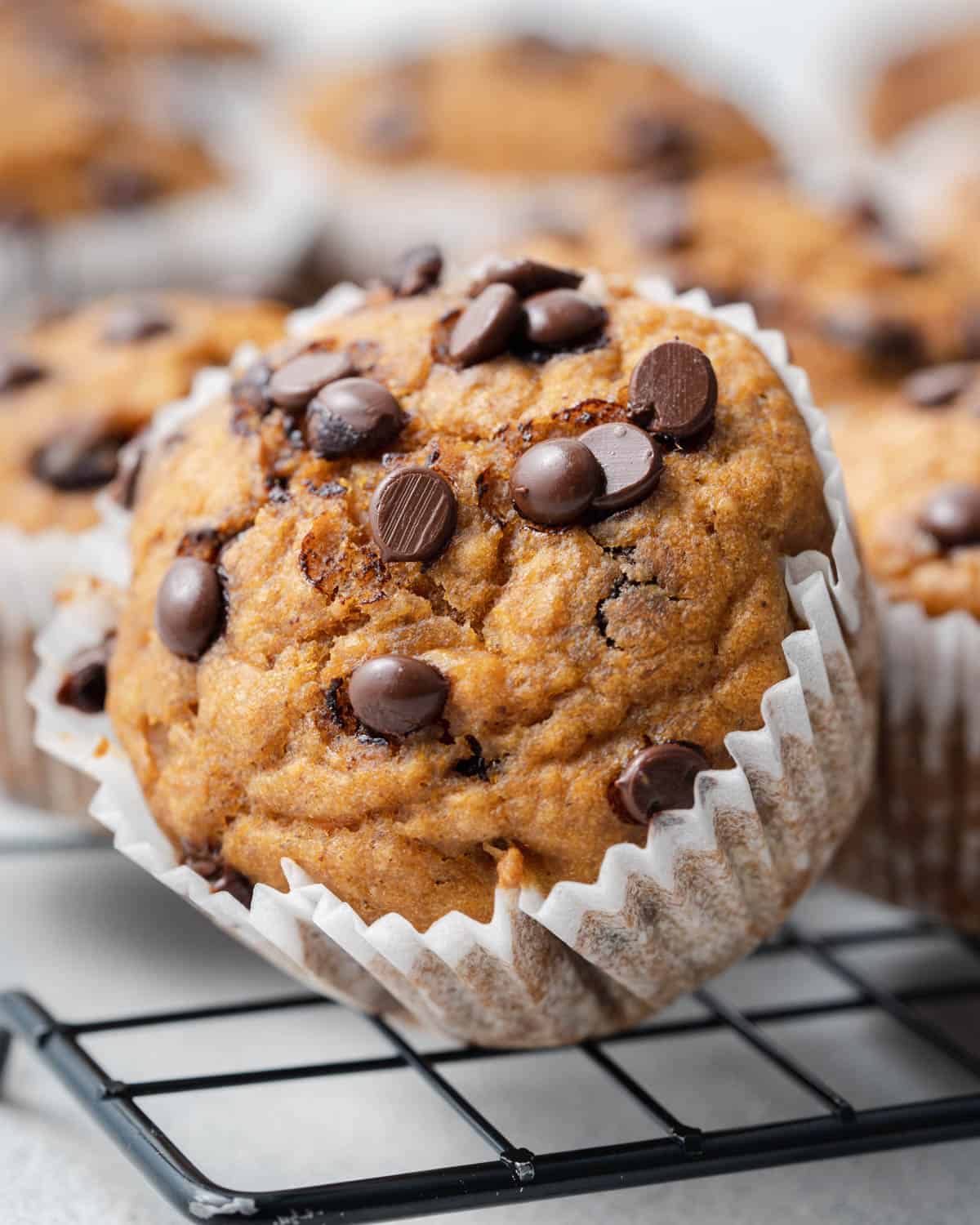 a single sweet potato muffin tipped to the side on a cooling wrack.