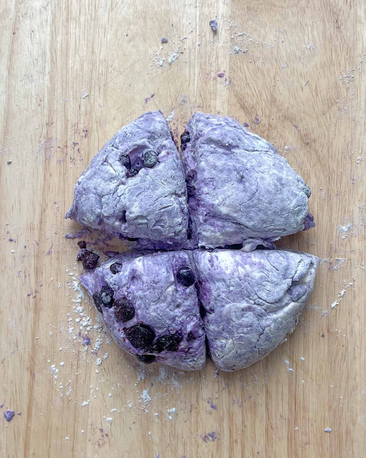 dough divided into 4 equal parts over a cutting board.