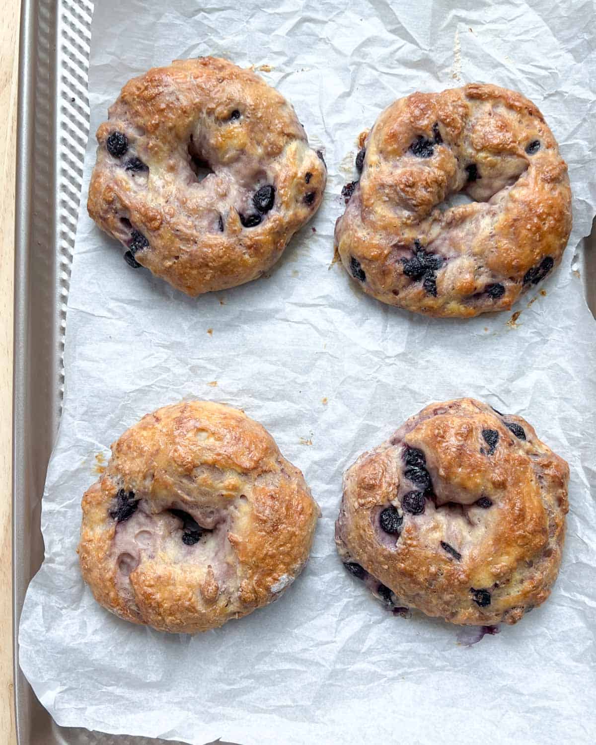 4 bakes bagels on a pan lined with parchment paper.