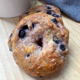 a single blueberry bagel on a wooden surface.