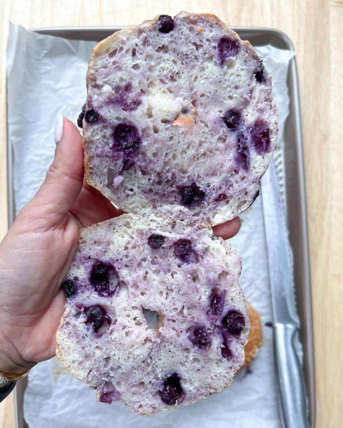 Blueberry bagel sliced in half.