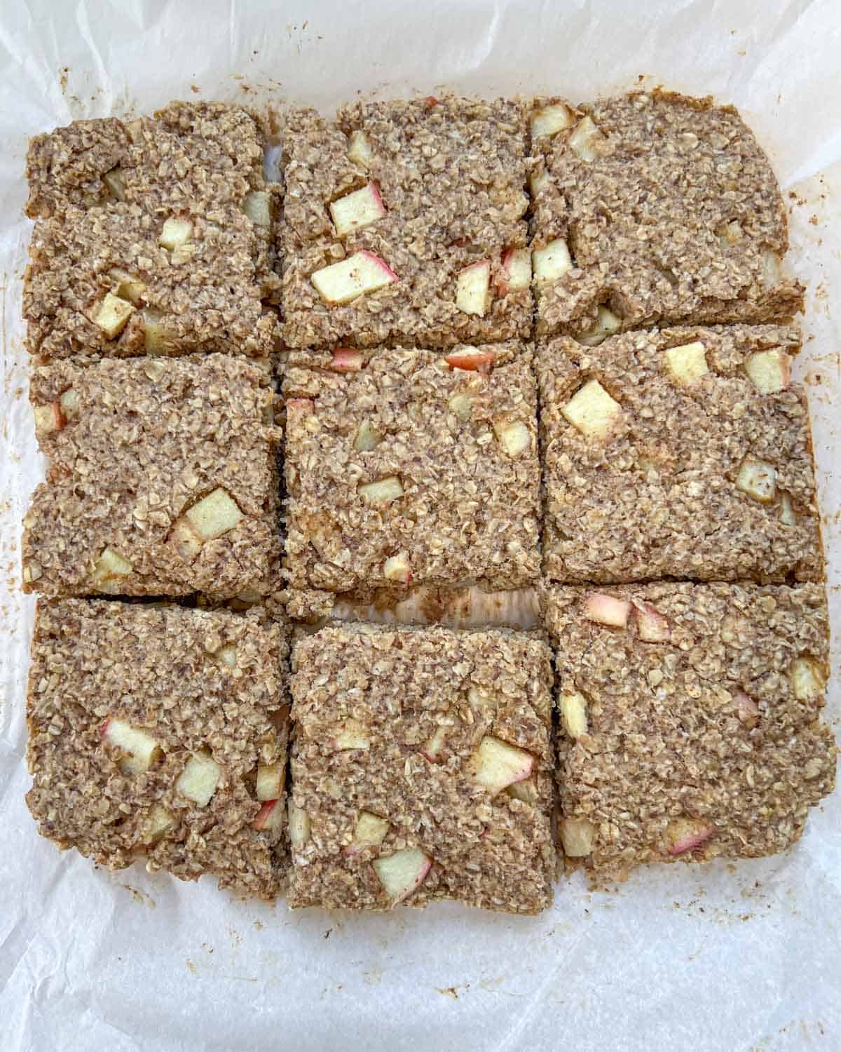 baked oatmeal with apples cut into 9 equal square bars.