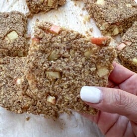 A hand holding an apple oatmeal bar.